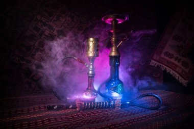 Nargile kömürü nargile kupa Arap iç de buhar bulutları yapma. Şark süsleme halı üzerinde. Şık oryantal shisha içinde karanlık arka ışık ile. Shisha reklam için. Seçici odak