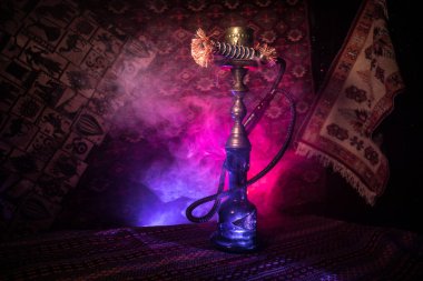 Nargile kömürü nargile kupa Arap iç de buhar bulutları yapma. Şark süsleme halı üzerinde. Şık oryantal shisha içinde karanlık arka ışık ile. Shisha reklam için. Seçici odak