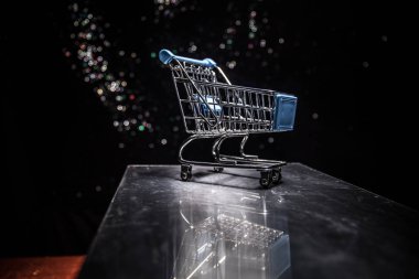 Karanlık, sisli arka planda fotokopi alanı olan boş bir alışveriş arabası. Mali kriz kavramı.