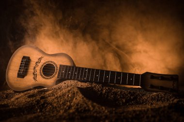 Müzik konsepti. Akustik gitar ile kopya alanı dumanla ışık demeti altında karanlık bir arka plan üzerinde izole. Gitar telleri, yakın çekim. Seçici odak.