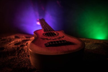 Müzik konsepti. Akustik gitar ile kopya alanı dumanla ışık demeti altında karanlık bir arka plan üzerinde izole. Gitar telleri, yakın çekim. Seçici odak.