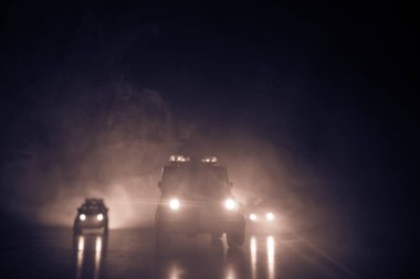 Police cars at night. Police car chasing a car at night with fog background. 911 Emergency response police car speeding to scene of crime. Selective focus clipart