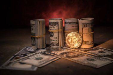 Bitcoin (sanal para) para ile toplu bize dolar koyu tonda sisli arka plan üzerinde. Seçici odak. Dijital para ve Bitcoin kavramı.