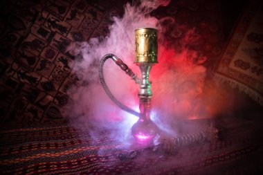 Nargile kömürü nargile kupa Arap iç de buhar bulutları yapma. Şark süsleme halı üzerinde. Şık oryantal shisha içinde karanlık arka ışık ile. Shisha reklam için. Seçici odak