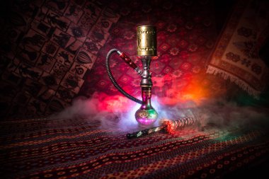 Nargile kömürü nargile kupa Arap iç de buhar bulutları yapma. Şark süsleme halı üzerinde. Şık oryantal shisha içinde karanlık arka ışık ile. Shisha reklam için. Seçici odak