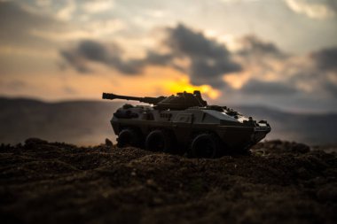 Savaş kavramı. Askeri savaş sis gökyüzü arka plan, Dünya Savaşı askerler siluetleri aşağıda bulutlu manzarası gün batımında dövüş sahnesinde siluetleri. Saldırı sahne. Zırhlı araçlar. tank içinde hareket