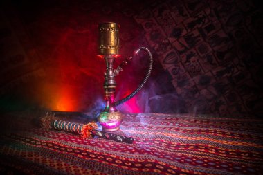 Nargile kömürü nargile kupa Arap iç de buhar bulutları yapma. Şark süsleme halı üzerinde. Şık oryantal shisha içinde karanlık arka ışık ile. Shisha reklam için. Seçici odak