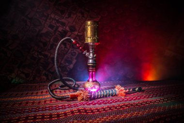 Nargile kömürü nargile kupa Arap iç de buhar bulutları yapma. Şark süsleme halı üzerinde. Şık oryantal shisha içinde karanlık arka ışık ile. Shisha reklam için. Seçici odak