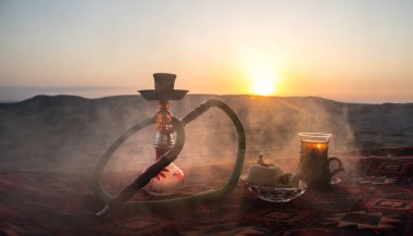 Nargile kömürü nargile kupa çöl de buhar bulutları açık yapma. Şark süsleme halı Doğu çay töreni üzerinde. Şık oryantal shisha günbatımı arka plan üzerinde. Seçici odak