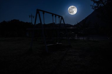 Gece fotoğraf metal Swing Moon ile gece açık duruyor. Kimse yok. Yalnızlık kavramı