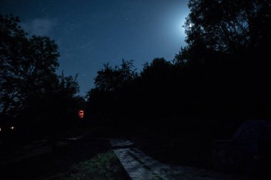 Binanın Orman geceleri ay veya vintage kır evi ile bulutlar ve yıldız ile gece dağ gece manzarası. Yaz gecesi. Uzun pozlama ile çekilen fotoğraf
