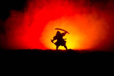 Savaşçı bir kılıç siluet bir gökyüzü ninja ile. Samuray koyu tonda sisli arka plan ile dağın zirvesinde. Seçici odak