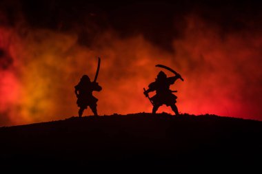 Düelloda iki samurais silüeti. İki samurais ve günbatımı gökyüzü ile hayal et. Seçici odak