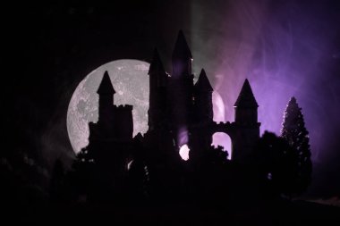 Sisli dolunay gizemli Ortaçağ kalesinde. Gotik tarzı eski kale geceleri terk edilmiş. Seçici odak