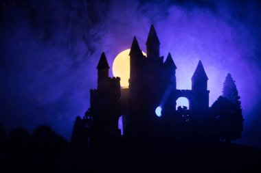 Sisli dolunay gizemli Ortaçağ kalesinde. Gotik tarzı eski kale geceleri terk edilmiş. Seçici odak