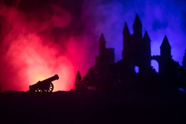 Süvari ve piyade ile ortaçağ savaş sahnesi. Siluetleri şekiller ayrı nesneler olarak mücadele eski Gotik kale ile koyu tonda sisli arka plan savaşçılar arasında