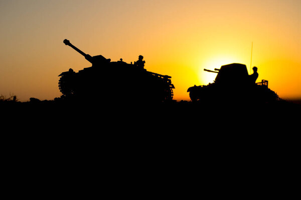 War Concept. Military silhouettes fighting scene. World War German Tanks and soldiers silhouettes at sunset. Attack scene. Armored vehicles. Tanks battle