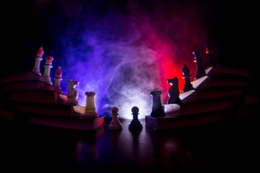 İş hiyerarşisi. Satranç taşları ile strateji kavramı. Kralın üst bir piramit kitapların üzerinde dururken satranç. Tonda ışık ile karanlık sisli arka plan. Kopya alanı.