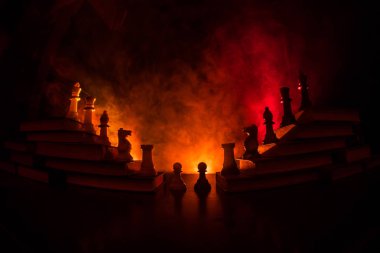 İş hiyerarşisi. Satranç taşları ile strateji kavramı. Kralın üst bir piramit kitapların üzerinde dururken satranç. Tonda ışık ile karanlık sisli arka plan. Kopya alanı.