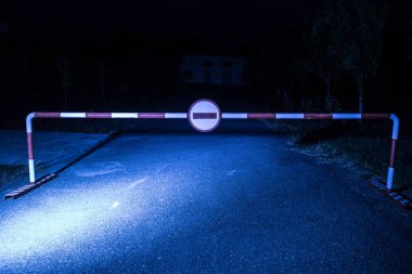 Yanlış yöne kavramı. Bariyer ile gece bir giriş oturum açın. Bariyer ayakta yolda korkunç hayaletler ya da manyak ile bina perili. Tehlikeli bölge hakkında uyarı