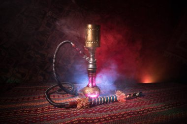 Nargile kömürü nargile kupa Arap iç de buhar bulutları yapma. Şark süsleme halı üzerinde. Şık oryantal shisha içinde karanlık arka ışık ile. Shisha reklam için. Seçici odak