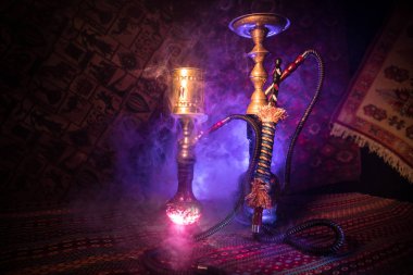 Nargile kömürü nargile kupa Arap iç de buhar bulutları yapma. Şark süsleme halı üzerinde. Şık oryantal shisha içinde karanlık arka ışık ile. Shisha reklam için. Seçici odak