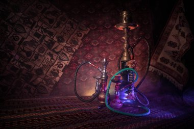 Nargile kömürü nargile kupa Arap iç de buhar bulutları yapma. Şark süsleme halı üzerinde. Şık oryantal shisha içinde karanlık arka ışık ile. Shisha reklam için. Seçici odak