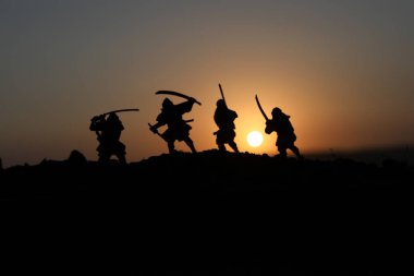 Düelloda dört samurais silüeti. İki samurais ve günbatımı gökyüzü ile hayal et. Seçici odak