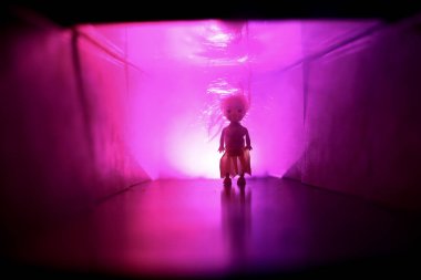 Ürpertici siluet koyu terk edilmiş binada. Korku manyak genel kavram ya da kabine kapılar ile karanlık koridor ve korkunç korku bebek ile farklı pozlar ayakta silüeti ışıklarla hakkında.