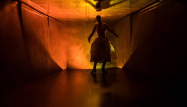 Ürpertici siluet koyu terk edilmiş binada. Korku manyak genel kavram ya da kabine kapılar ile karanlık koridor ve korkunç korku bebek ile farklı pozlar ayakta silüeti ışıklarla hakkında.