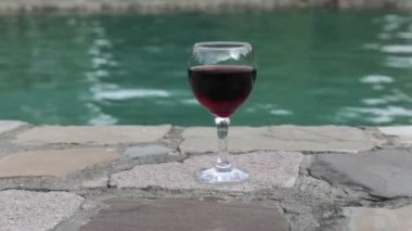 Havuz içinde uzun bardak içki. Ferahlık yaz gününde. Mor suyu kokteyl veya asma. Dağ orman arka plan. Seçici odak