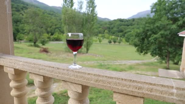 户外野餐设置与葡萄酒或葡萄酒在阳台上的绿色领域和山脉的背景 选择性聚焦 — 图库视频影像