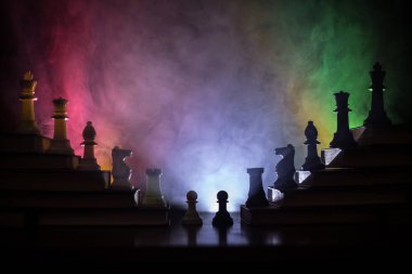 İş hiyerarşisi. Satranç taşları ile strateji kavramı. Kralın üst bir piramit kitapların üzerinde dururken satranç. Tonda ışık ile karanlık sisli arka plan. Kopya alanı.