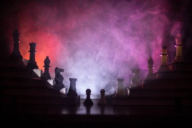 İş hiyerarşisi. Satranç taşları ile strateji kavramı. Kralın üst bir piramit kitapların üzerinde dururken satranç. Tonda ışık ile karanlık sisli arka plan. Kopya alanı.