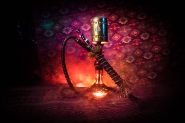 Nargile kömürü nargile kupa Arap iç de buhar bulutları yapma. Şark süsleme halı üzerinde. Şık oryantal shisha içinde karanlık arka ışık ile. Shisha reklam için. Seçici odak
