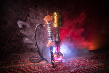 Nargile kömürü nargile kupa Arap iç de buhar bulutları yapma. Şark süsleme halı üzerinde. Şık oryantal shisha içinde karanlık arka ışık ile. Shisha reklam için. Seçici odak