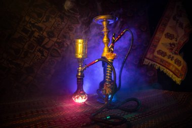 Nargile kömürü nargile kupa Arap iç de buhar bulutları yapma. Şark süsleme halı üzerinde. Şık oryantal shisha içinde karanlık arka ışık ile. Shisha reklam için. Seçici odak