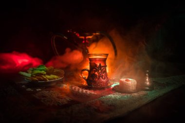 Nargile kömürü nargile kupa Arap iç de buhar bulutları yapma. Şark süsleme halı Doğu çay töreni üzerinde. Şık oryantal shisha içinde karanlık arka ışık ile. Seçici odak