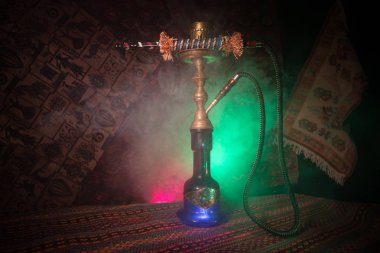 Nargile kömürü nargile kupa Arap iç de buhar bulutları yapma. Şark süsleme halı üzerinde. Şık oryantal shisha içinde karanlık arka ışık ile. Shisha reklam için. Seçici odak