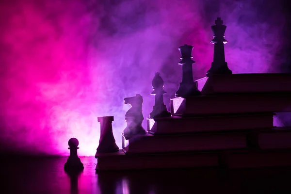 事業階層 チェスの駒の戦略コンセプト チェス上部王と書籍のピラミッドの上に立っています トーンの光で暗い霧の背景 コピー スペース — ストック写真