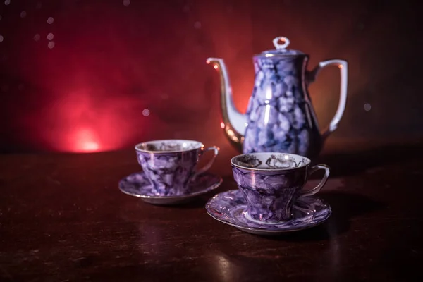 咖啡或茶道的概念主题 老式的陶瓷茶或咖啡壶在深色色调的背景与光和烟雾的杯子 文本的空白 选择性聚焦 — 图库照片