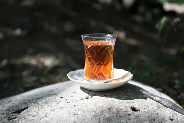 在森林的石头上玻璃上的东方红茶 东方茶的概念 Armudu 传统杯 绿色自然背景 选择性聚焦 — 图库照片