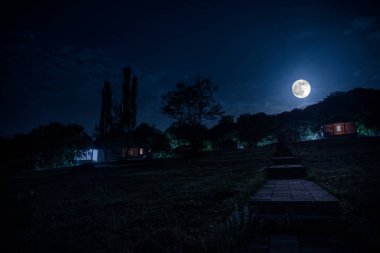 Binanın Orman geceleri ay veya vintage kır evi ile bulutlar ve yıldız ile gece dağ gece manzarası. Yaz gecesi. Uzun pozlama ile çekilen fotoğraf
