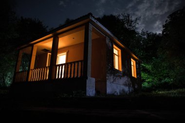 Binanın Orman geceleri ay veya vintage kır evi ile bulutlar ve yıldız ile gece dağ gece manzarası. Yaz gecesi. Uzun pozlama ile çekilen fotoğraf