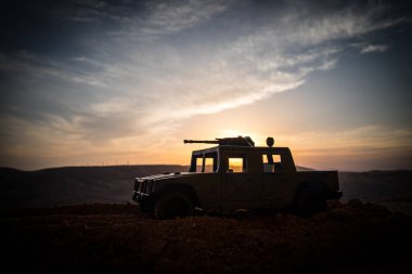 Gün batımı arka plan üzerinde askeri devriye arabası. Ordu savaş kavramı. Eylemde silahlı ve zırhlı silüeti. Dekore edilmiş. Seçici odak
