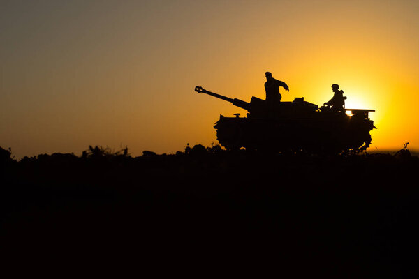 War Concept. Military silhouettes fighting scene. World War German Tanks and soldiers silhouettes at sunset. Attack scene. Armored vehicles. Tanks battle