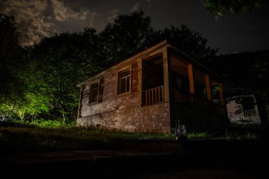 Binanın Orman geceleri ay veya vintage kır evi ile bulutlar ve yıldız ile gece dağ gece manzarası. Yaz gecesi. Uzun pozlama ile çekilen fotoğraf