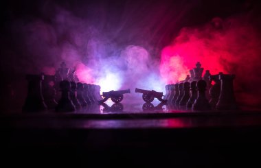 Satranç tahtası üzerinde iki top ile ortaçağ savaş sahnesi. Satranç oyununu kavramı iş fikirleri ve rekabet ve strateji fikirler duman ve sis karanlık bir arka plan üzerinde satranç figürleri.