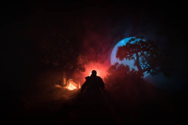 Yağmurluk ile onun el kavramı içinde parlayan fener karanlık ormanın gelen adam. Lamba korku katille silüeti. Dekorasyon