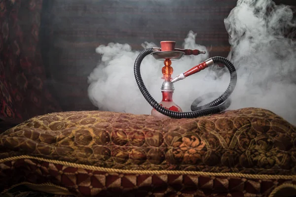 水烟碗上的水烟热煤制作阿拉伯内部的蒸汽云 地毯上的东方装饰品 时尚的东方水烟与背光 水烟广告 选择性聚焦 — 图库照片